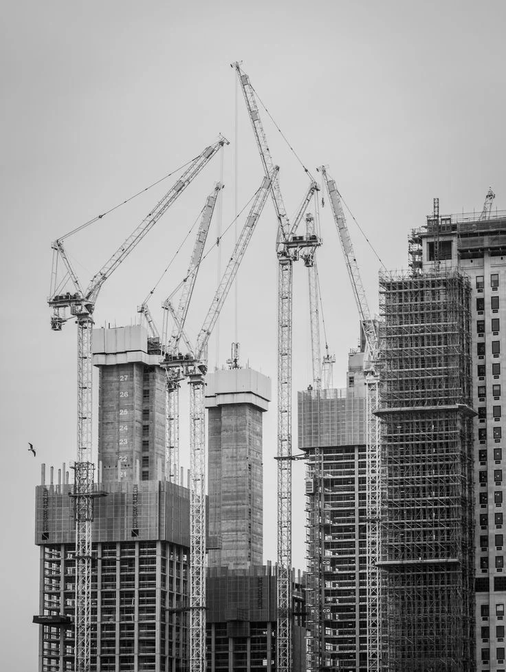 Cranes and a building under construction, illustrating real activity and interconnected work.